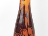 un vase en verre marron et orange posé sur un socle en bois