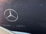 someone is holding a cell phone with a mercedes logo on it