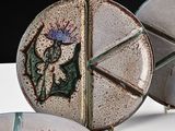 three plates with designs on them sitting on a table