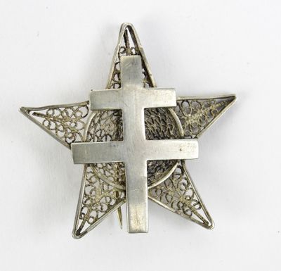 un gros plan d'une étoile en métal sur laquelle figure une croix