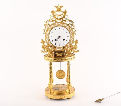 a gold clock that is sitting on a stand