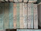 several old books are stacked on top of each other on a shelf