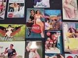 a lot of old coca cola advertisements on the table