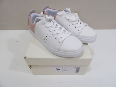 a pair of white shoes on a box on a table