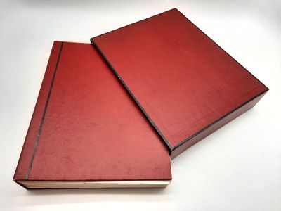 deux livres rouges posés l'un sur l'autre sur une surface blanche