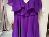 purple chiffon dress hanging on a hanger in front of a mirror