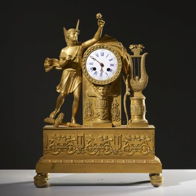 a gold clock with a statue on top of it
