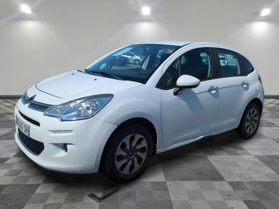 la petite voiture blanche est garée sur un carrelage à carreaux