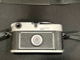 a camera that is sitting on a bag with a strap around it