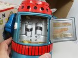 a person holding a toy clock in front of a box