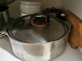 pots and pans are sitting on a shelf in a kitchen