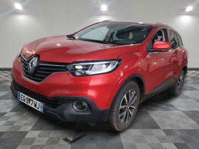 une voiture rouge garée dans un garage au sol en damier