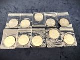 six different types of coins in plastic bags on a table