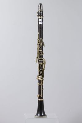 a black and gold clarinet sitting on top of a clear stand