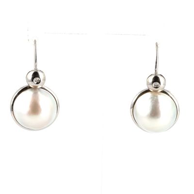 boucles d'oreilles en perles et diamants sur fond blanc