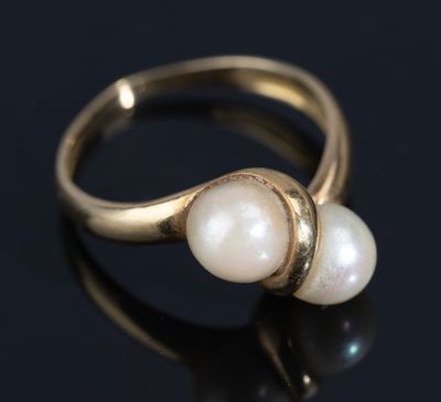 a close up of a gold ring with two pearls on it