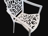 a white chair that is sitting on a black background