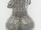 a large metal vase with a horse head on it
