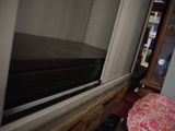 a small bed in the corner of a room next to a window