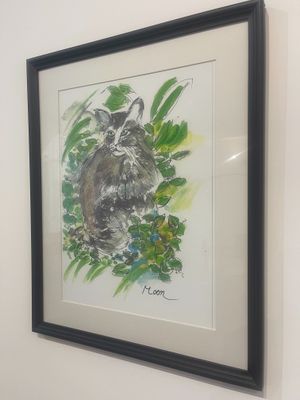 painting of a raccoon in a frame hanging on a wall