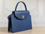 a blue handbag sitting on top of a wooden table
