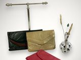 three different types of purses and a vase with flowers