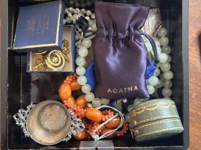 une boîte noire remplie d'objets divers posée sur une table en bois