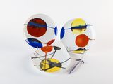 two plates with different designs on them on a white surface