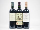 trois bouteilles de vin posées les unes à côté des autres sur une surface blanche