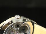the watch is on a black surface with a black background