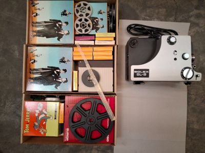 une boîte contenant un projecteur de films et une paire de ciseaux