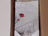 a box with a red rose in it on a table