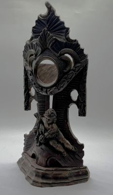a statue of a man holding a mirror on a stand
