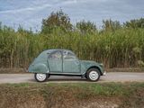 a small green car that is parked on the side of the road