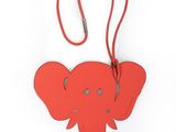 une étiquette à bagages en forme d'éléphant suspendue à une lanière en cuir rouge
