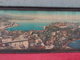 tableau encadré représentant une vue d'une ville avec une baie en arrière-plan