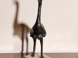statue of an ostrich and a bird on a wooden table