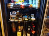 a mini fridge that has a lot of bottles of beer in it