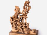 carved figurine of a man and woman on a boat surrounded by animals