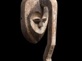 une image représentant une sculpture en bois représentant un visage sur fond noir