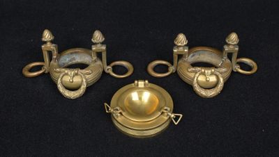 three antique brass door handles on a black background