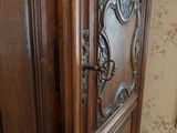 a wooden cabinet with a door and a mirror on the wall