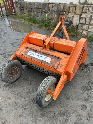 a picture of an orange lawn mower sitting on the ground
