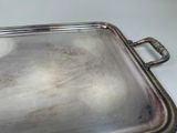 a silver tray with a handle on a white table