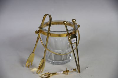 a glass with spoons and spoon rest on the table