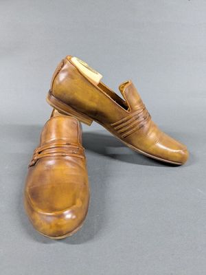 pair of men ' s brown leather shoes on a grey surface
