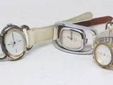 three watches are sitting next to each other on a white surface