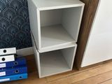 a white cabinet and a blue and white cabinet in the corner of a room