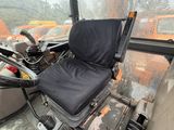 a seat on the back of a bus that is sitting in the rain