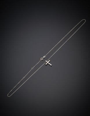 un collier en argent avec une croix et une chaîne sur fond noir